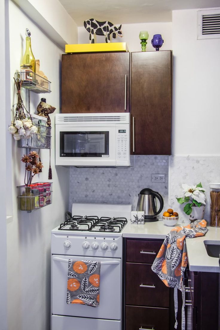 a kitchen with brown cabinets and white stove top oven next to a microwave on the wall