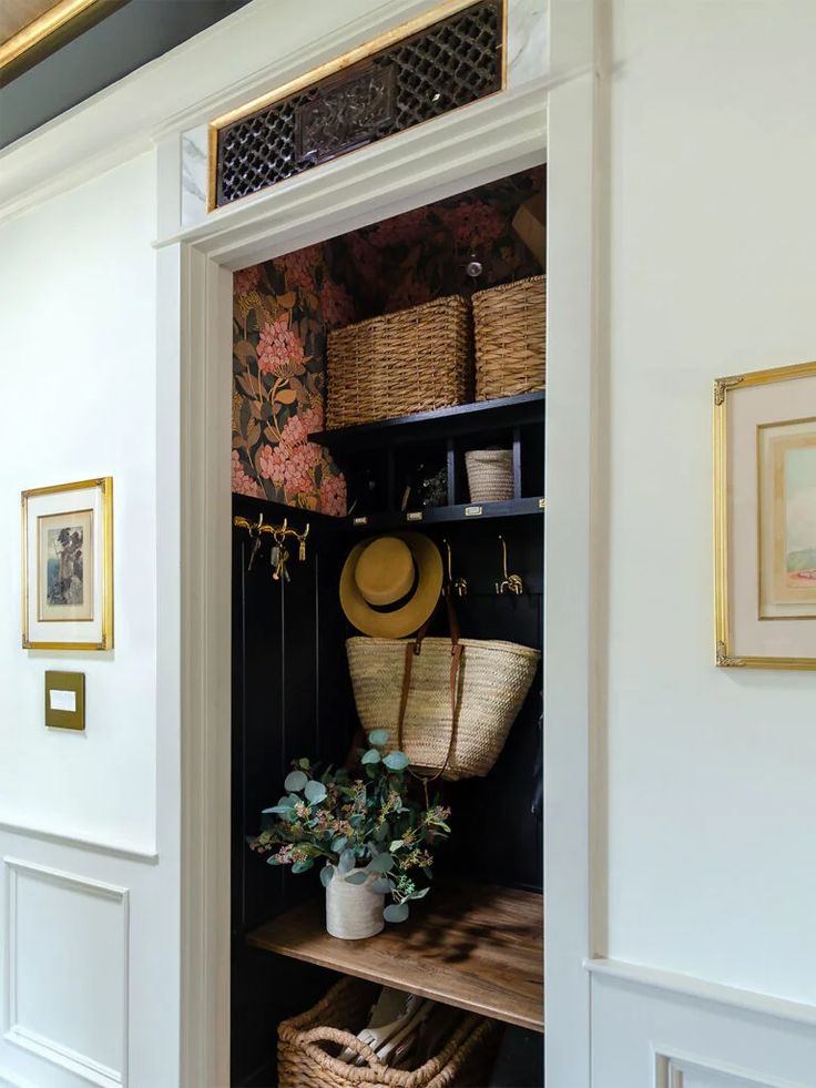 an open closet with baskets and hats on the shelf next to it is filled with plants