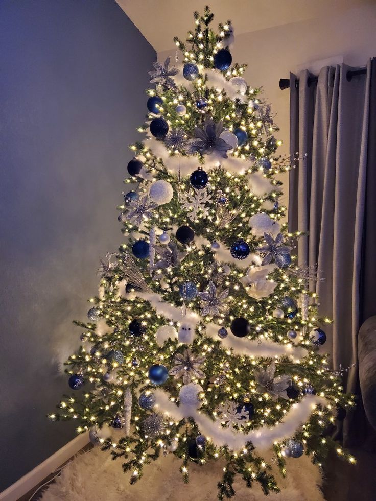 a white christmas tree with blue and silver ornaments