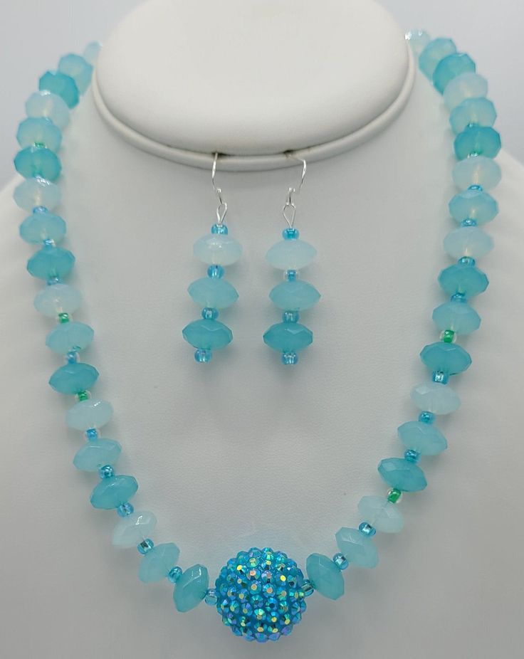 The 19 inch necklace is made with a sparkly round baby blue specialty bead in the center (1  inch circumference).  The rest of the necklace is made with matching round quartz beads and seed beads.  The closure on the necklace is a sterling silver toggle clasp.  Matching earrings are made with round quartz beads and the seed beads.  The earrings hang a total of 2 inches and have a sterling silver earring wire. Adjustable Light Blue Jewelry With Spacer Beads, Adjustable Beaded Aquamarine Jewelry, Light Blue Gemstone Beads For Jewelry Making, Blue Crystal Jewelry With Gemstone Beads, Beaded Turquoise Crystal Jewelry, Adjustable Turquoise Crystal Jewelry, Blue Crystal Round Bead Jewelry, Turquoise Beaded Crystal Jewelry, Blue Crystal Round Beads Jewelry