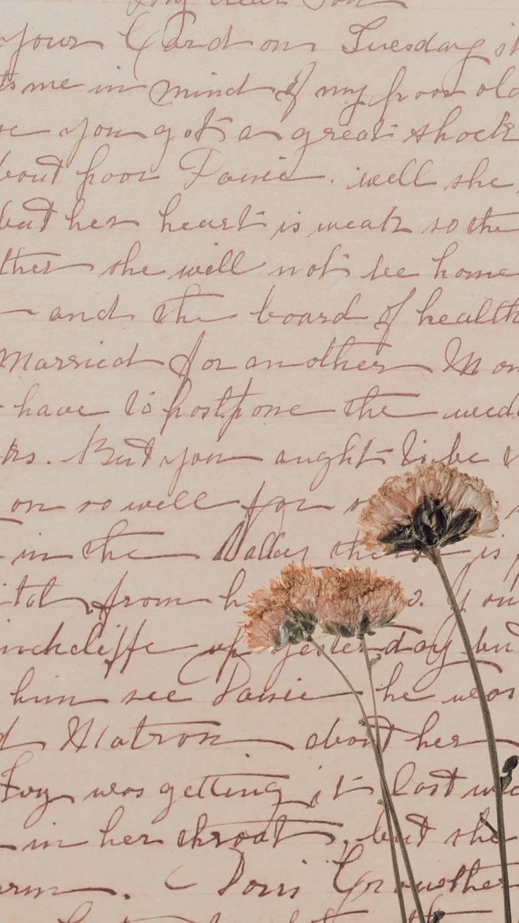 two flowers sitting on top of a piece of paper with writing written in cursive ink