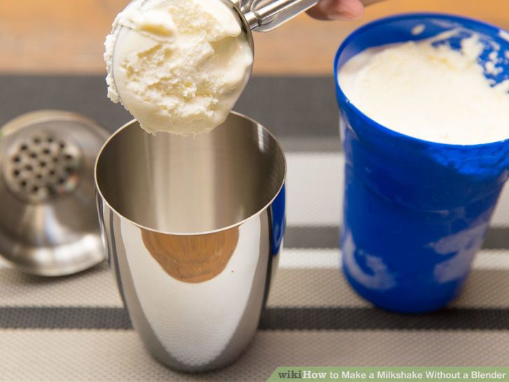 a person scooping ice cream out of a blue cup into a silver cup on top of a table