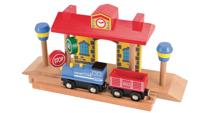 a wooden toy train with a building and stop sign