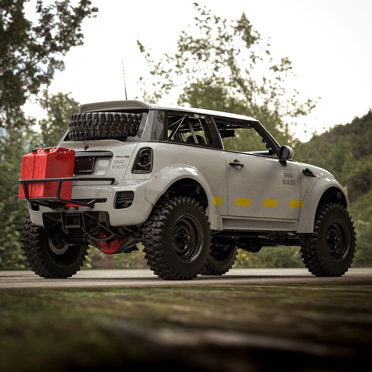 an off - road vehicle is parked on the side of the road in front of some trees