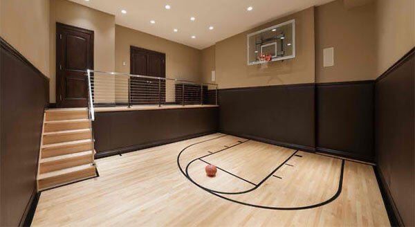 an indoor basketball court with stairs leading up to the upper level and a basketball hoop in the middle