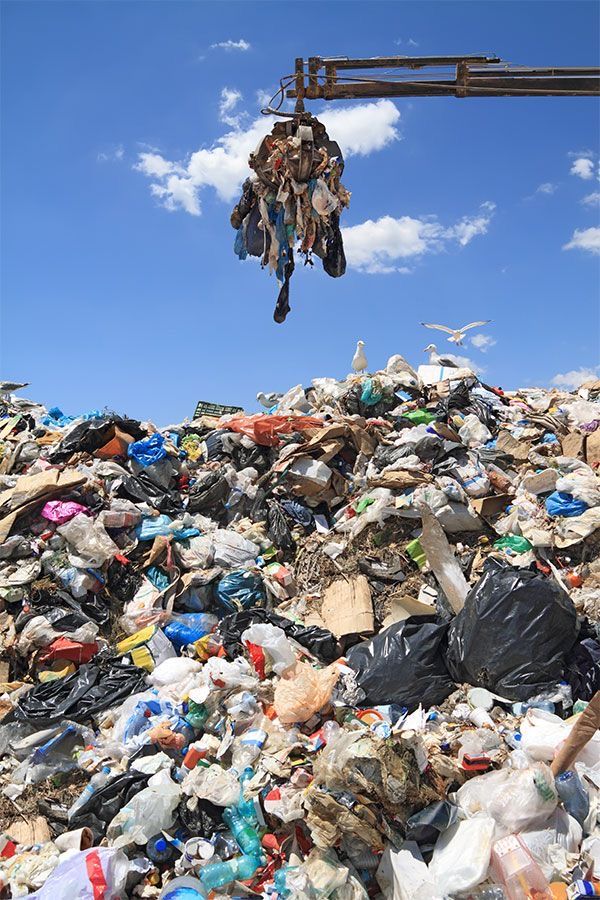 a pile of trash with a crane in the background and a blue sky above it