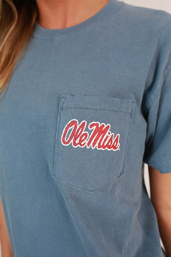 a woman wearing a blue ole mississippi pocket t - shirt