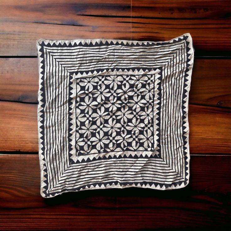 a black and white quilt sitting on top of a wooden floor