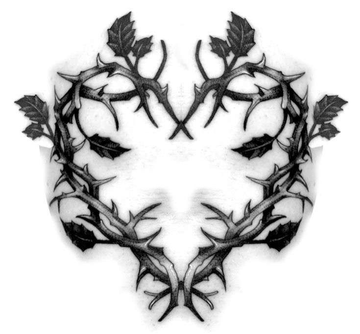 a black and white photo of leaves on the side of a face with an intricate design