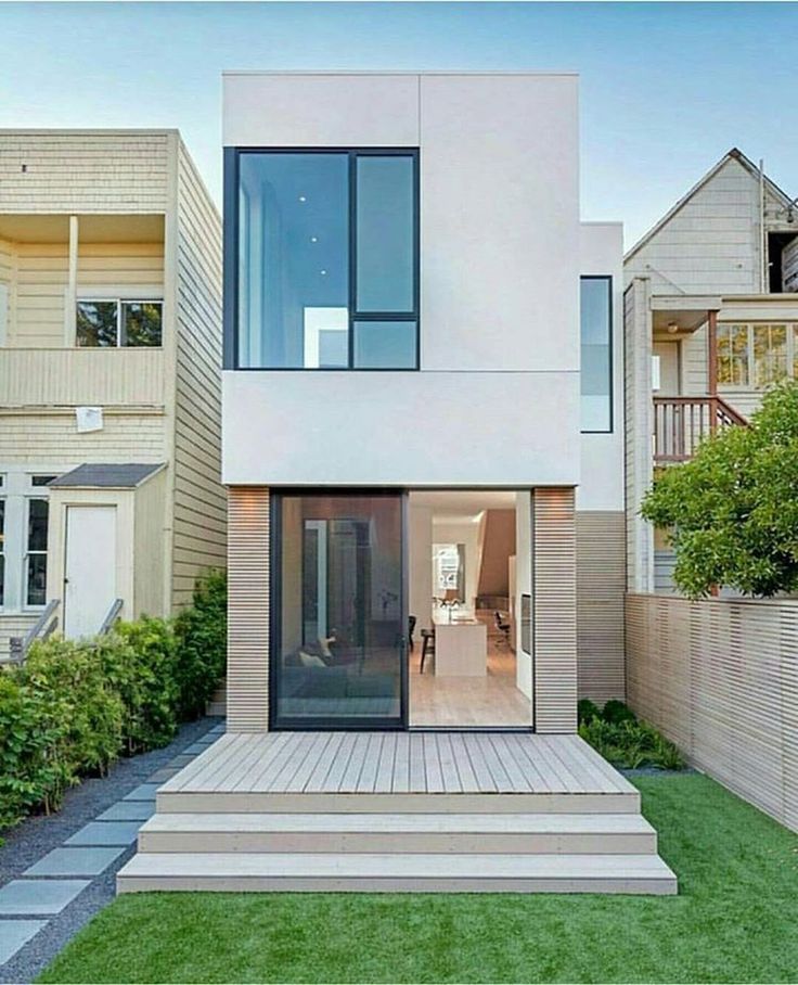 a modern house in the middle of a grassy area with stairs leading up to it