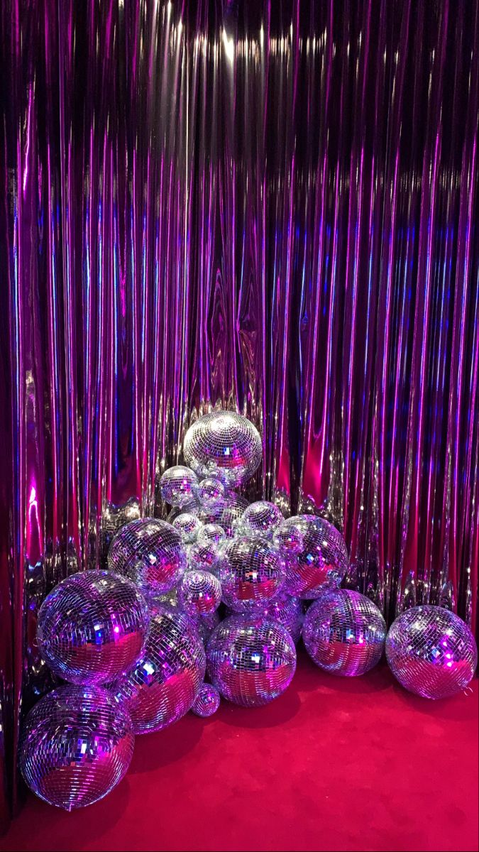 many shiny balls are stacked on top of each other in the middle of a red carpeted area