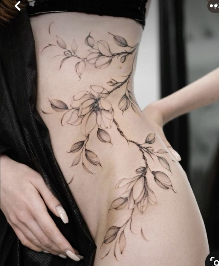 a woman's stomach with flowers on it and the bottom part of her body covered in tattoos