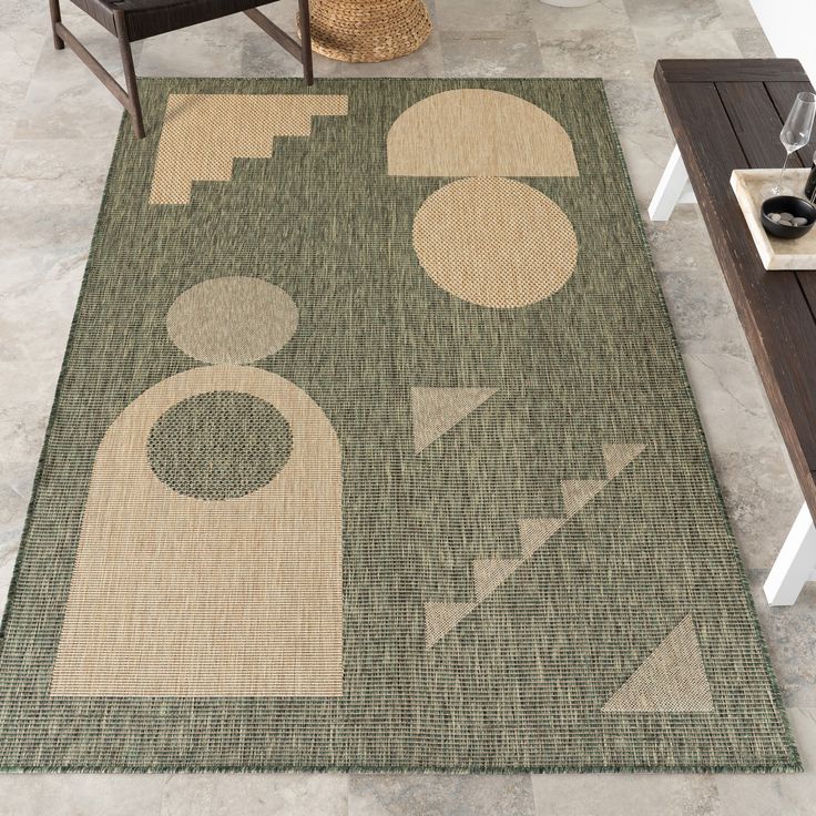 a large rug with an abstract design on the floor next to a chair and coffee table