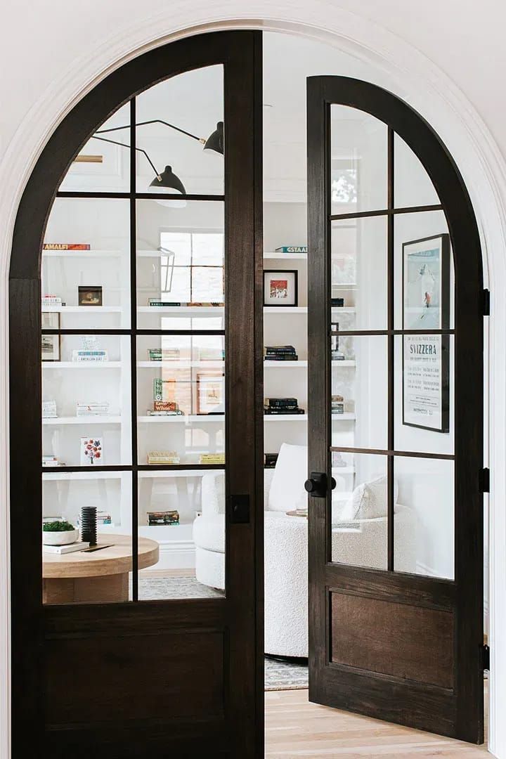 an arched glass door leading into a living room