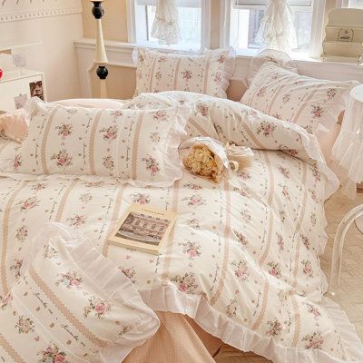 a bed with white and pink bedspreads in a bedroom