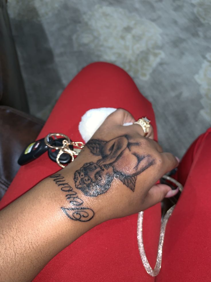 a person with a tattoo on their arm holding a cell phone in one hand and a chain around the other