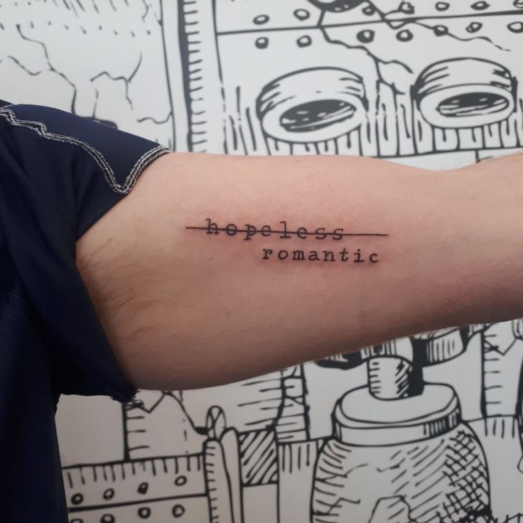 a man's arm with a tattoo on it that reads, hopeless romantic