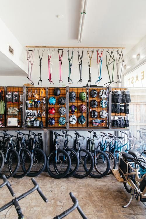 many bicycles are lined up against the wall in a bike shop with lots of them