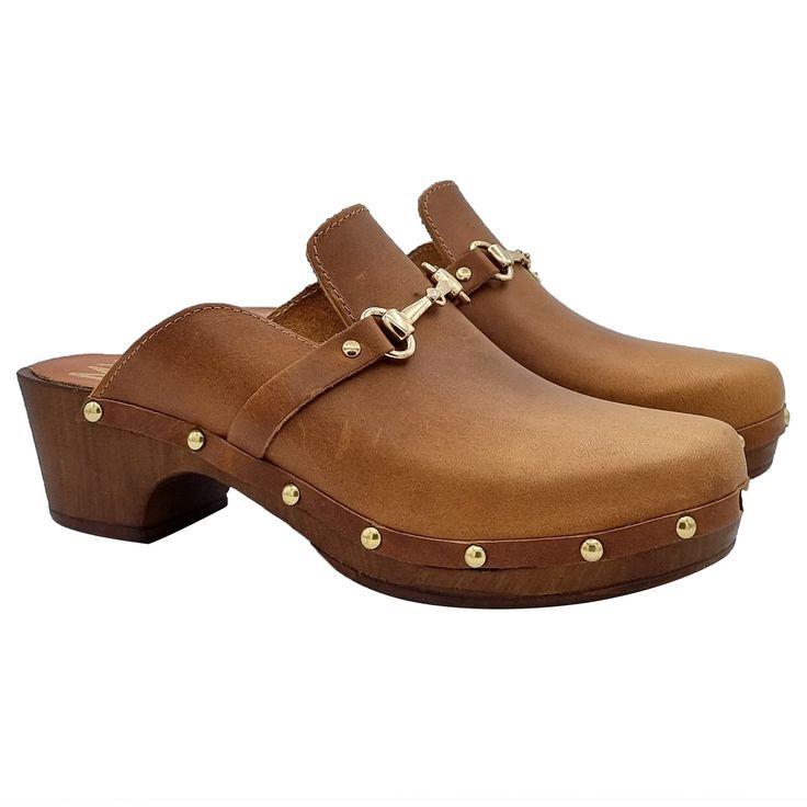 Swedish-style clogs are practical, adapt to any situation and offer absolute comfort! Clogs with brown wood effect base Upper in leather-colored leather, with golden accessory Closed rounded toe Heel height 4.5 cm and plateau 2 cm Stable and comfortable made entirely in ITALY. Craftsmanship. BEFORE COMPLETING YOUR PURCHASE, DON'T FORGET TO CHECK THE SIZE! Wooden Slip-on Mules, Brown Wooden Mules With Round Toe, Brown Wood Mules With Round Toe, Brown Wood Slip-on Clogs, Brown Wooden Round Toe Mules, Classic Brown Clogs With Leather Lining, Brown Clogs With Leather Lining And Round Toe, Brown Leather Slip-on Clogs, Gold Leather Mules With Leather Sole