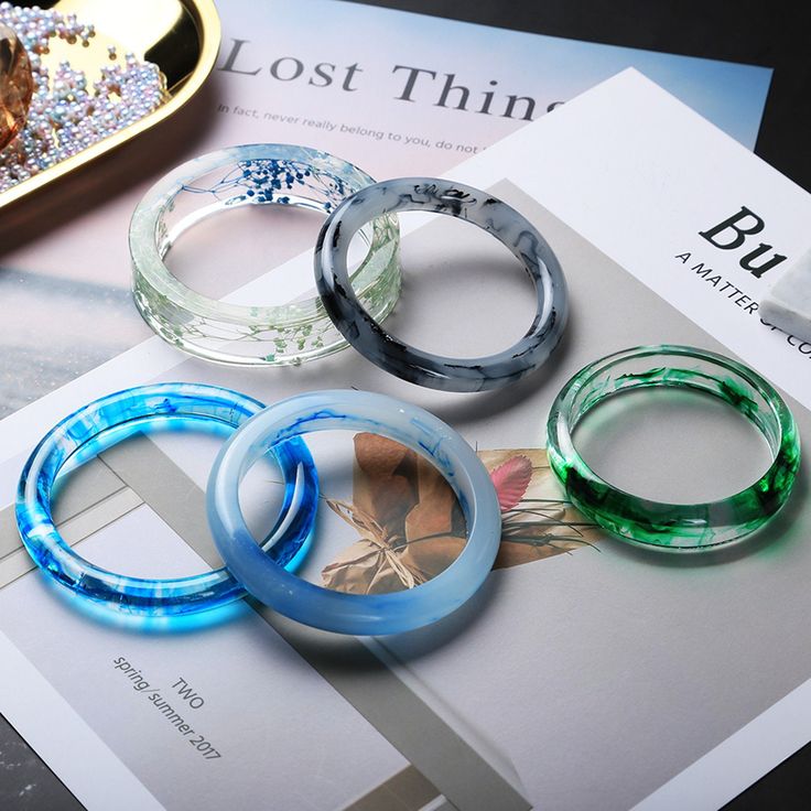 four different colored rings sitting on top of a magazine