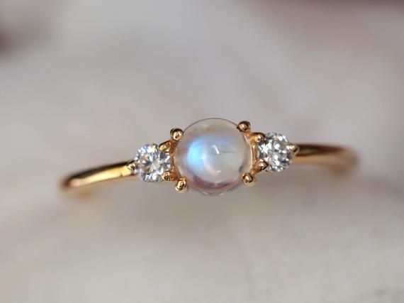 Rainbow moonstone ring, Moonstone engagement ring, stacking ring, Gold moonstone ring, Natural moonstone diamond ring, dainty promise ring Same design can be made also with other custom gemstones per request. Product details:- Solid gold (9k, 14k)- approx 5mm  moonstone round (AAA quality)- 2.5mm Diamonds ( G, VS-SI )- Band size is 1.4mm- Made to order - 8 to 10 business days.Ring size - US 3 to US 9 (for smaller or larger ring size, please contact)Please select your size at the drop down menu. Elegant Stackable Moonstone Ring With Diamond, Dainty Diamond Moonstone Ring For Anniversary, Moonstone Gold Ring, Celestial Stackable Moonstone Ring For Anniversary, Dainty Moonstone Ring With Diamond, Dainty Moonstone Diamond Ring, Celestial Style Stackable Moonstone Ring, Celestial Stackable Moonstone Ring, Dainty Moonstone Ring With Rose Cut Diamonds For Wedding