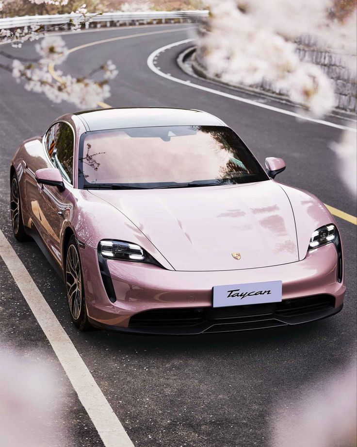 a pink sports car driving down the road