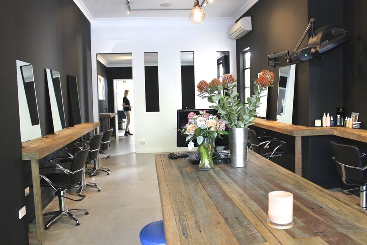 a salon with wooden tables and flowers in a vase