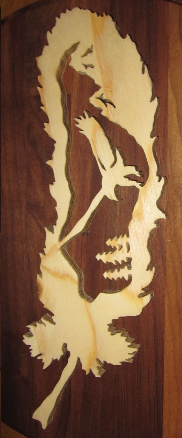 a wood carving of a man's face with long hair and mustaches on it