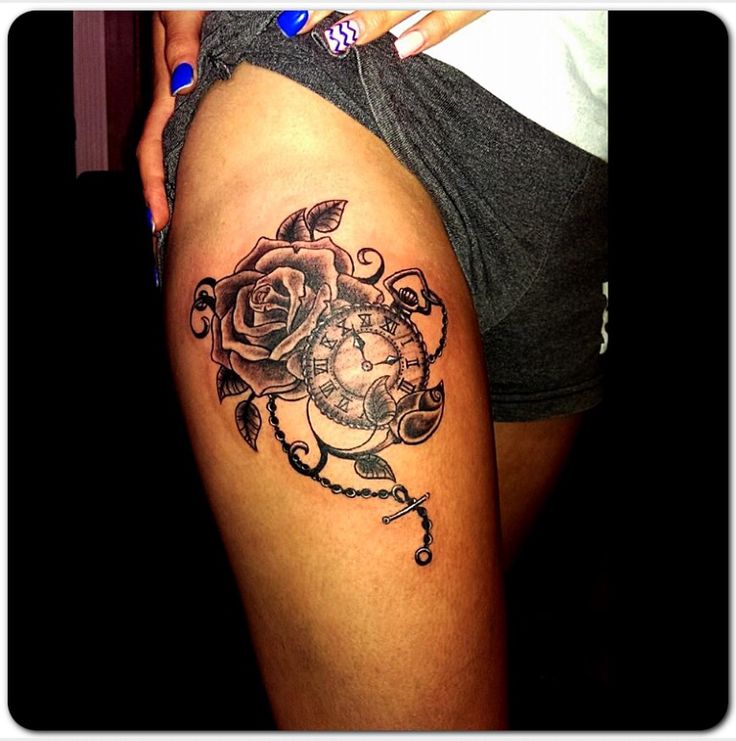 a woman's thigh with a rose and clock tattoo on the side of her leg