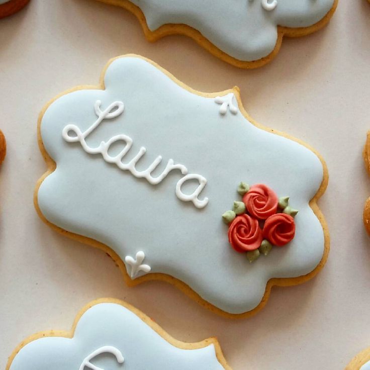 decorated cookies with the word laura spelled in cursive writing and flowers on them