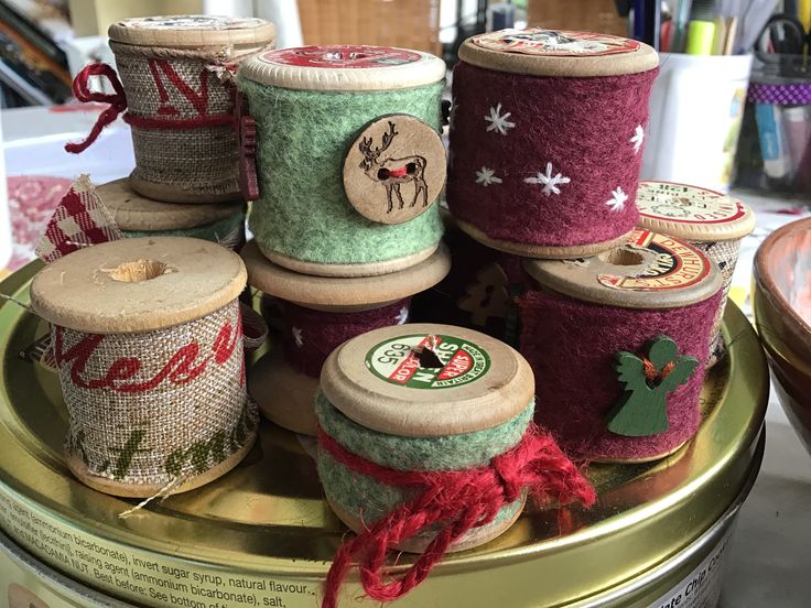 several spools of yarn sitting on top of a tin with other spools