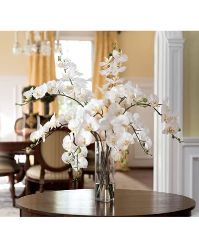 a vase with white flowers sitting on top of a table