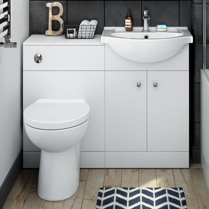 a white toilet sitting next to a bath tub in a bathroom under a mirror above a sink