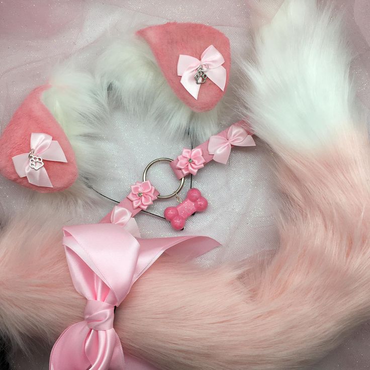 a pink and white cat tail, collar, keychain, and hat