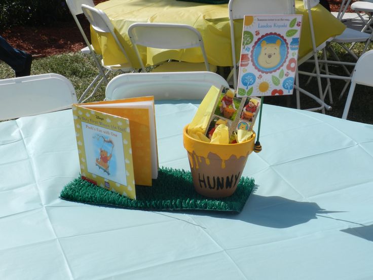 there is a bucket with candy in it on the table at this baby's first birthday party