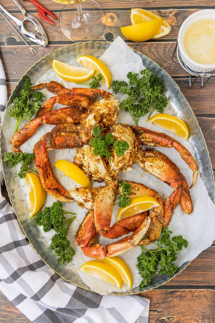 cooked lobsters with lemon wedges and parsley garnish on a platter