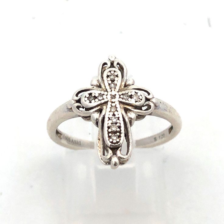 * Designer Ashi 925 Sterling Silver Round Diamond Cross Ring * Ring Size: 7 * Band Width: 1.75 * Top Of Ring Measures: 5/8" X 1/2" * Height: 1/8" * Weight: 2.5 Tgw * 11 Round Diamonds Measure Approximately 0.9 Mm To 0.8 Mm * Ring Can Be Resized For An Additional Fee. * Marked: Ashi * 925 * S * 1/20 * Condition: As Pictured. * S6138 Spiritual White Gold Rings For Formal Occasions, Silver Spiritual Rings For Formal Occasions, Anniversary Rings In White Gold And Sterling Silver, Diamond Cross Ring For Gift, Diamond Cross Rings For Gifts, Cross-shaped Diamond Ring For Gift, Classic Silver Cross-shaped Rings, Spiritual White Gold Ring Stamped 925, Classic Silver Cross Rings