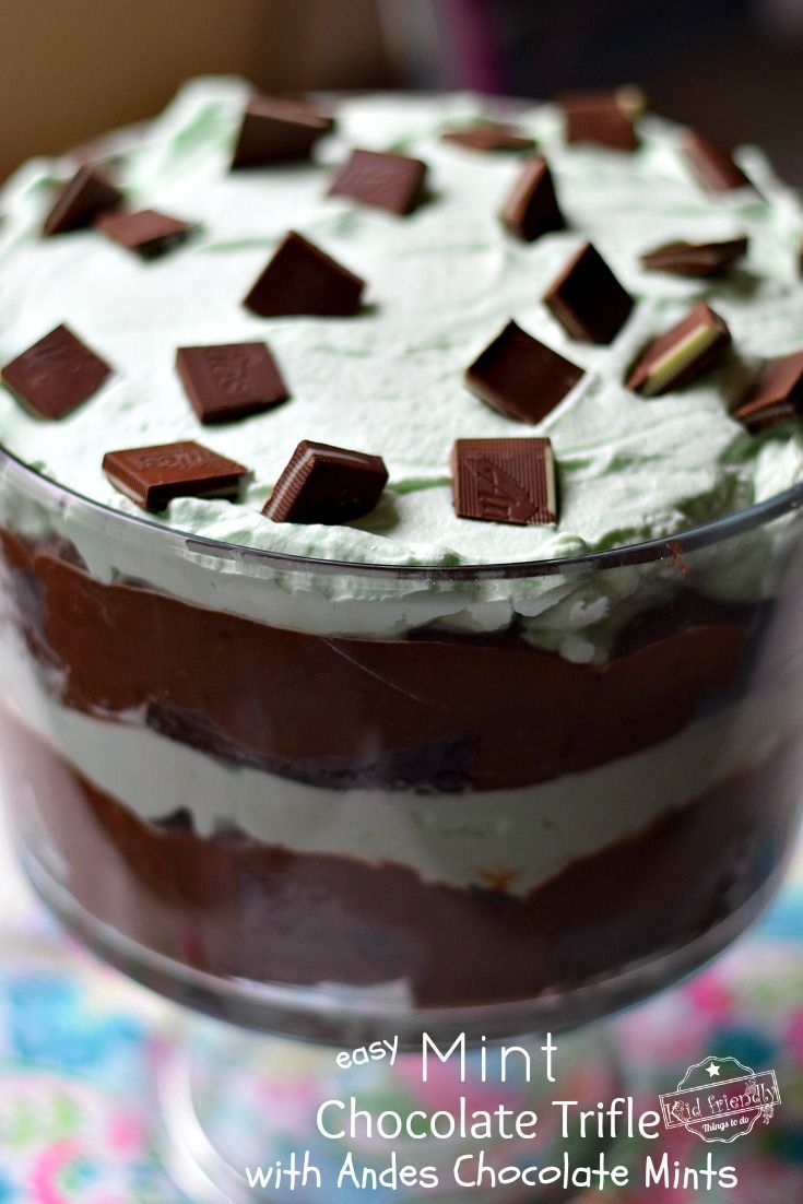 a chocolate trifle with mints and white frosting in a glass dish on a table