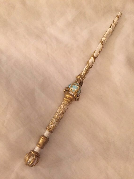 an ornate gold and turquoise beaded necklace on a white cloth covered table with a light colored background