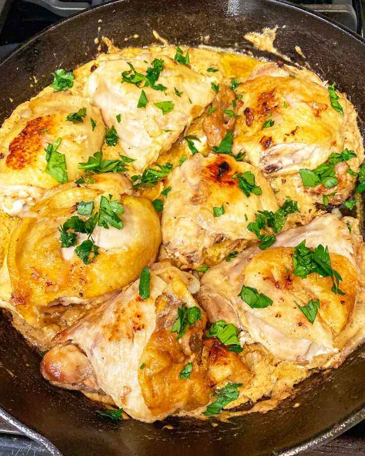 a skillet filled with meat and vegetables on top of a stove