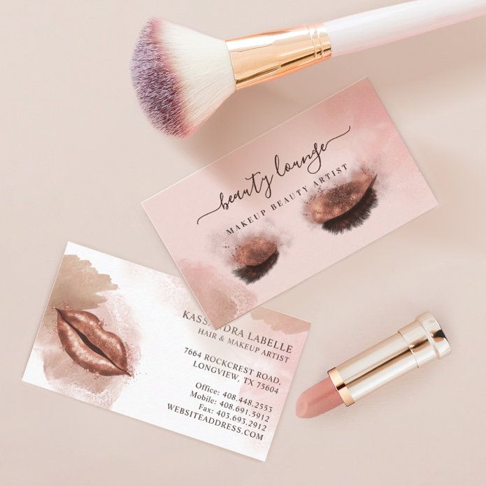 makeup brush and business card laying next to it