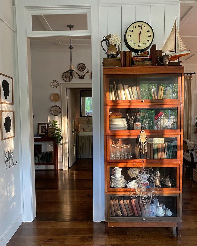 a bookshelf filled with lots of books on top of a hard wood floor