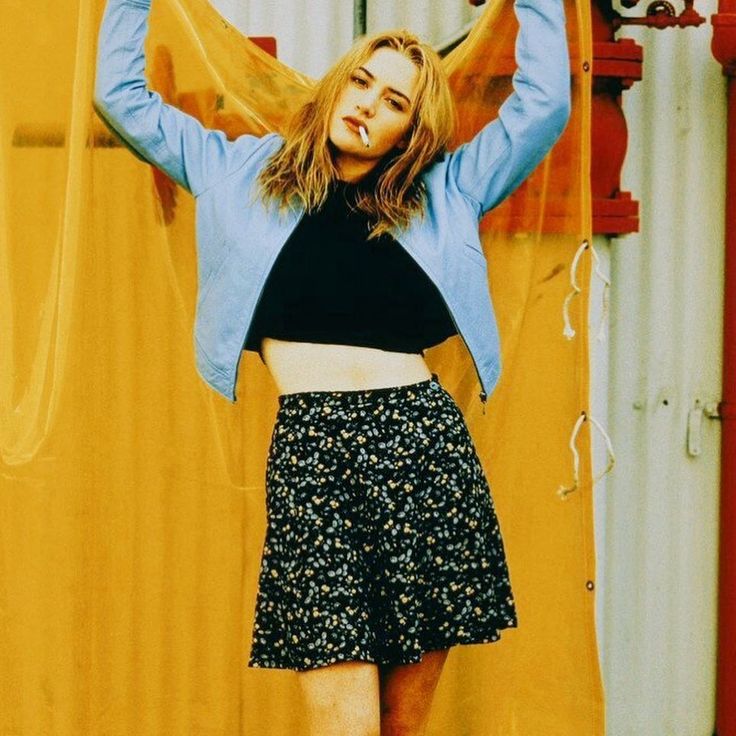 a woman is posing with her hands in the air