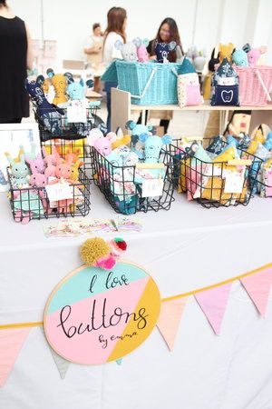 there is a table with many small baskets on it and people in the background looking at them