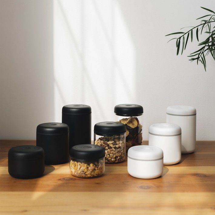 there are many containers on the table with food in them and one has a plant next to it