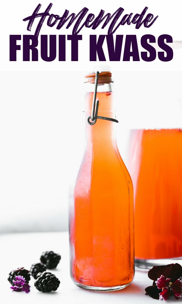 two bottles filled with fruit juice next to blackberries