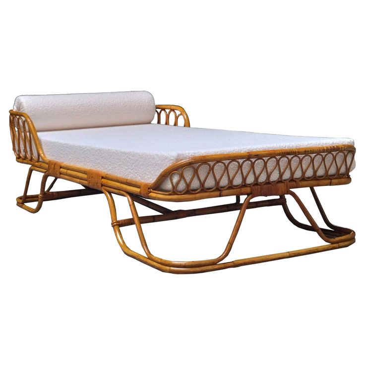 a bed that is made out of bamboo and has white sheets on top of it