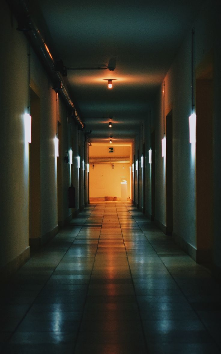 an empty hallway with light coming through the doors