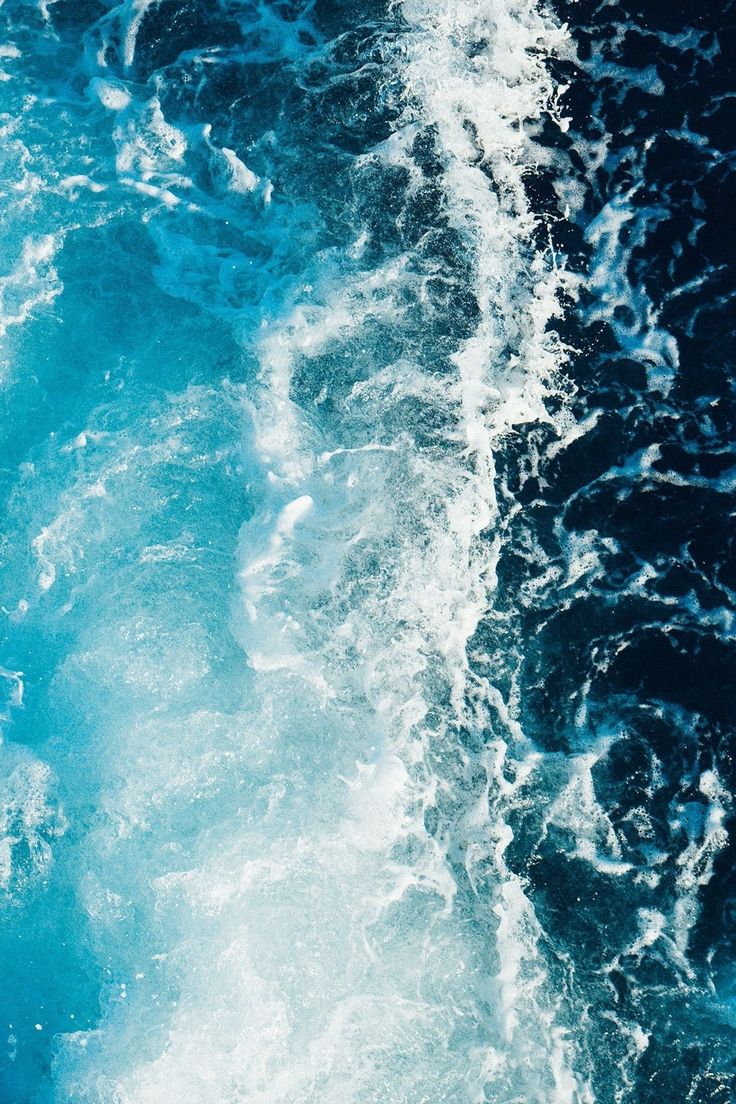 the water is blue and foamy as it looks like waves are coming in from the ocean