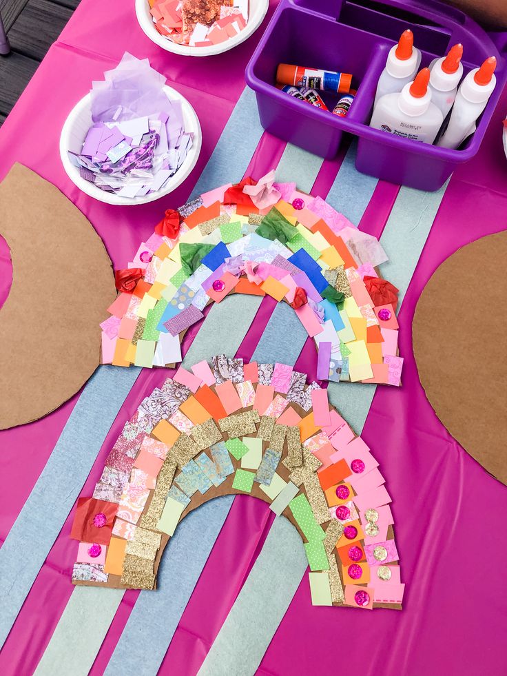 the table is set up with paper and crafting supplies to make a rainbow decoration